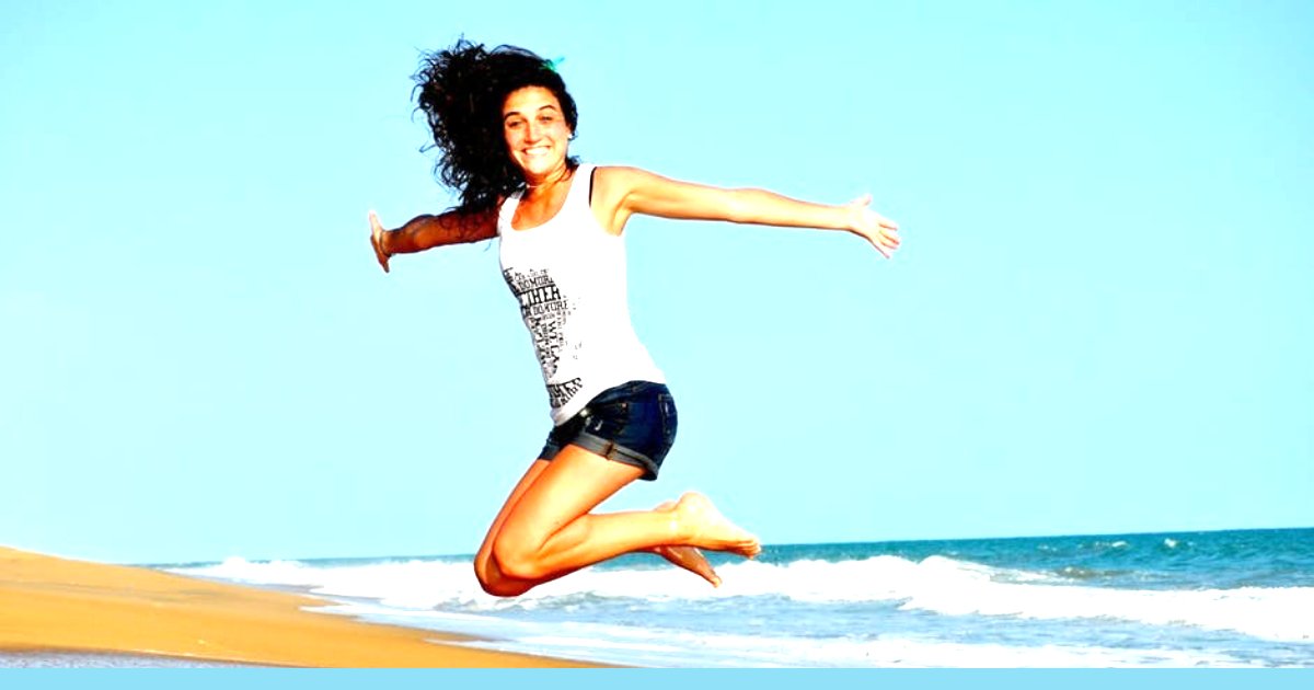 Happy jumping woman at the beach excited at her occupation in the sales lane 