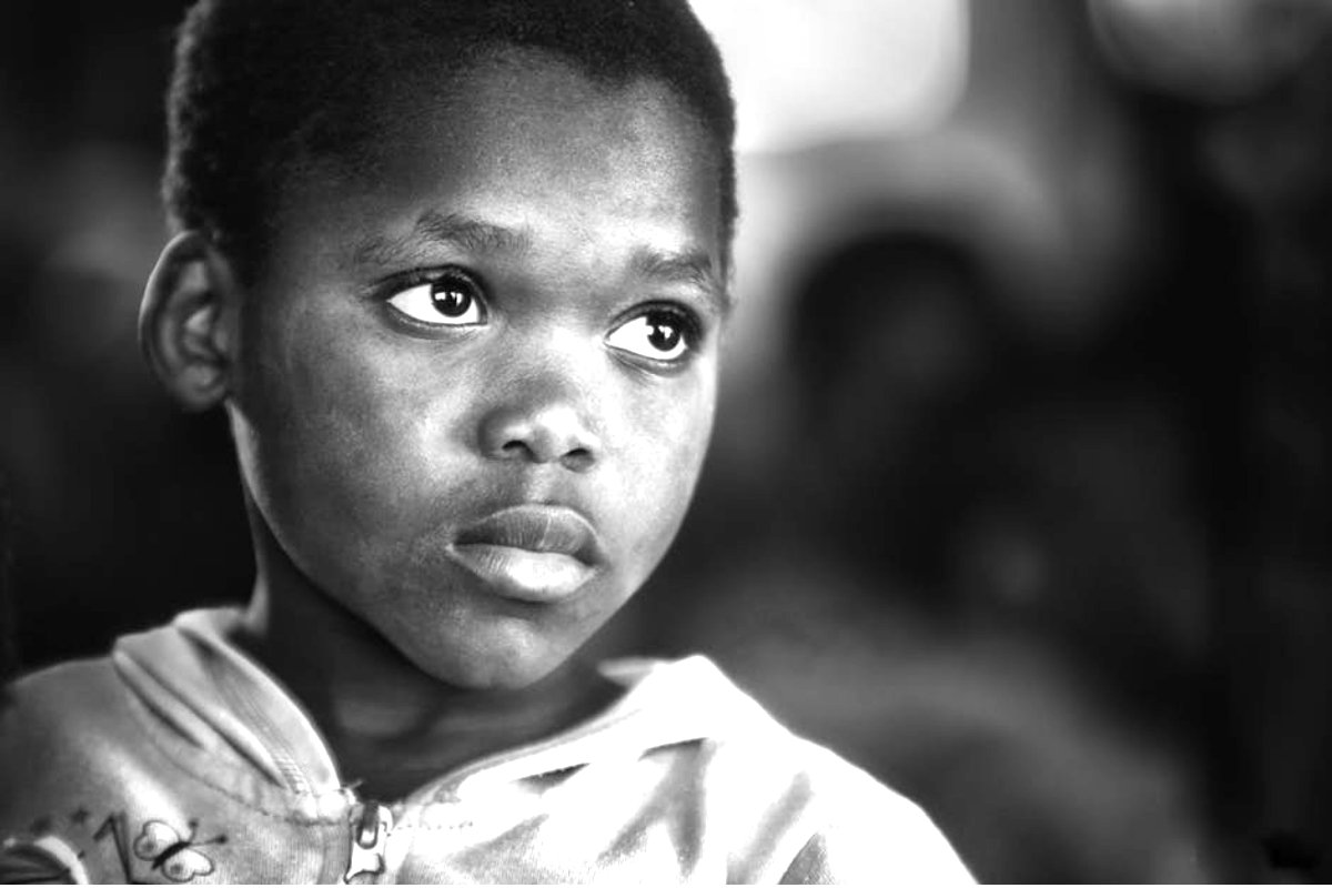 African american kid gazing up wondering about a future life in the sales lane