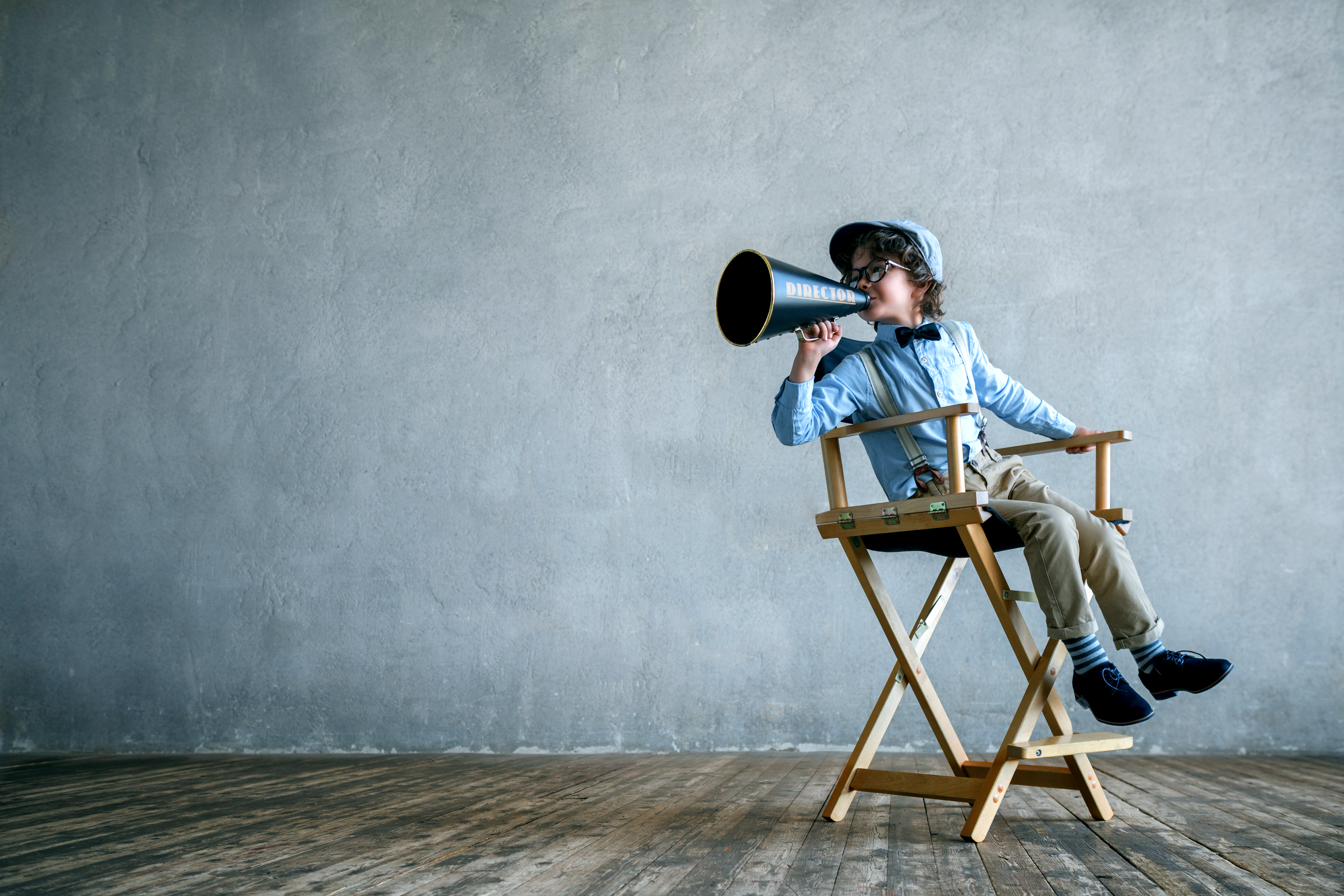 Screaming director kid with a megaphone making a movie about life in the sales lane 