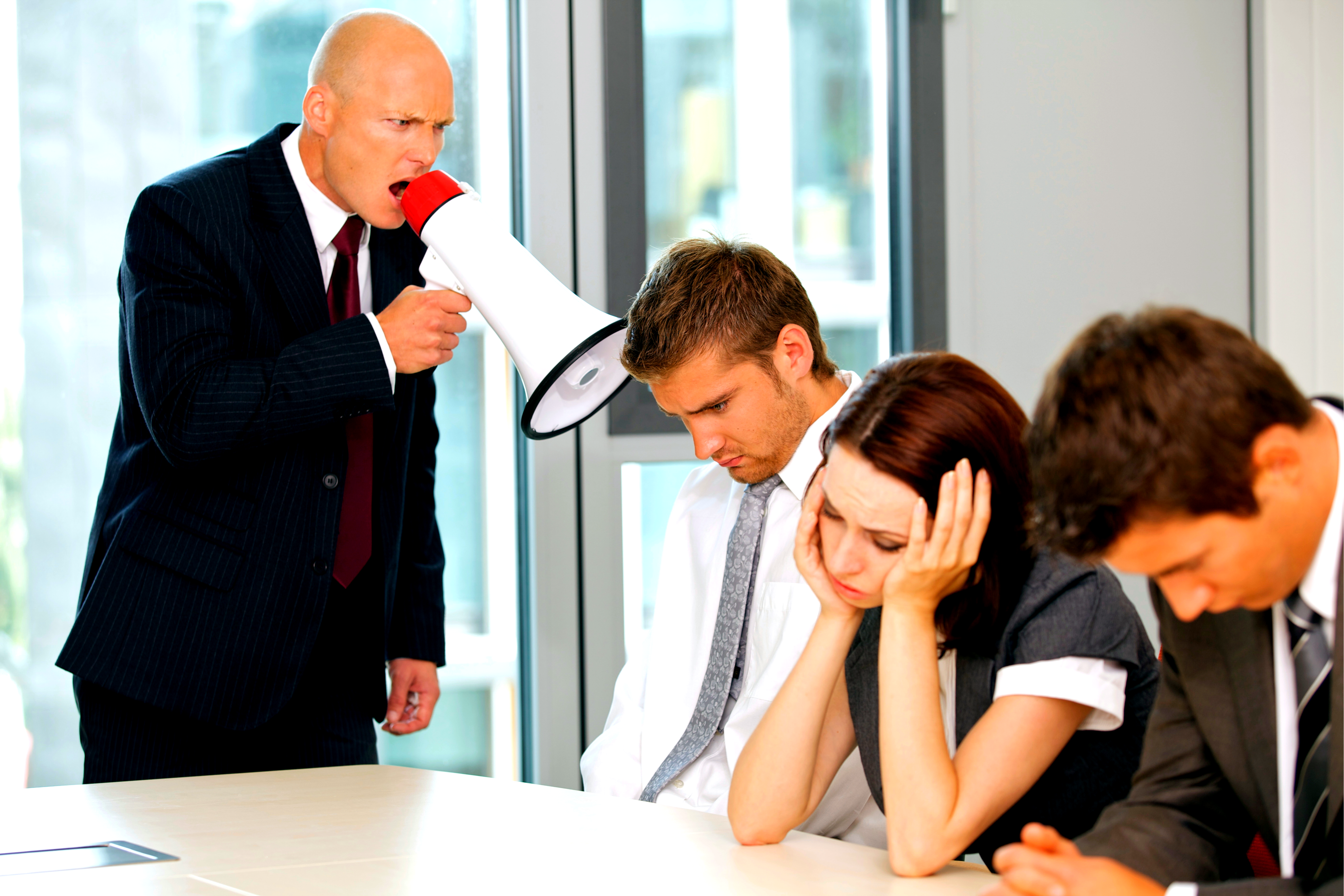 Businessman yelling at his salespeople for failing to do their jobs