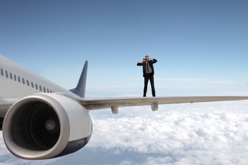 Business man practicing lead generation on airplane wing